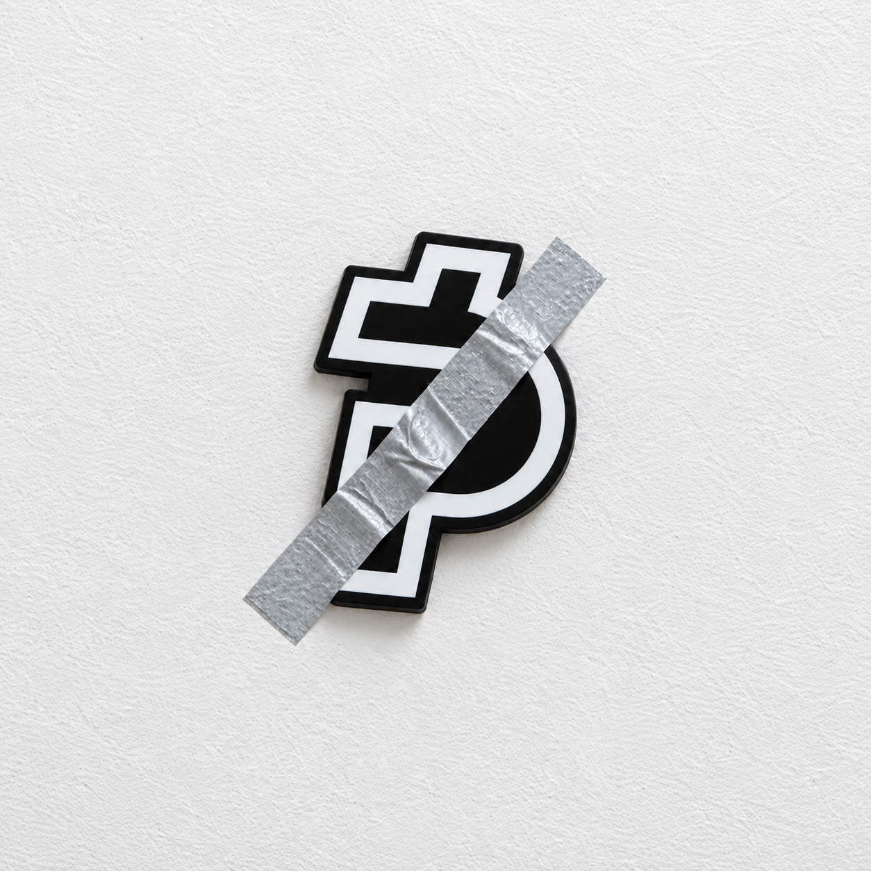 The black and white PAID emblem fixed to a white wall with one narrow strip of silver tape